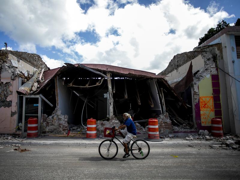 A cyclist rides past a destroyed building in Guanica, Puerto Rico. The island was hit by a series of earthquakes over the past couple of weeks, leading to a state of emergency, power outages and millions of dollars of damage. A cyclist rides past a destroyed building in Guanica, Puerto Rico. The island was hit by a series of earthquakes over the past couple of weeks, leading to a state of emergency, power outages and millions of dollars of damage.