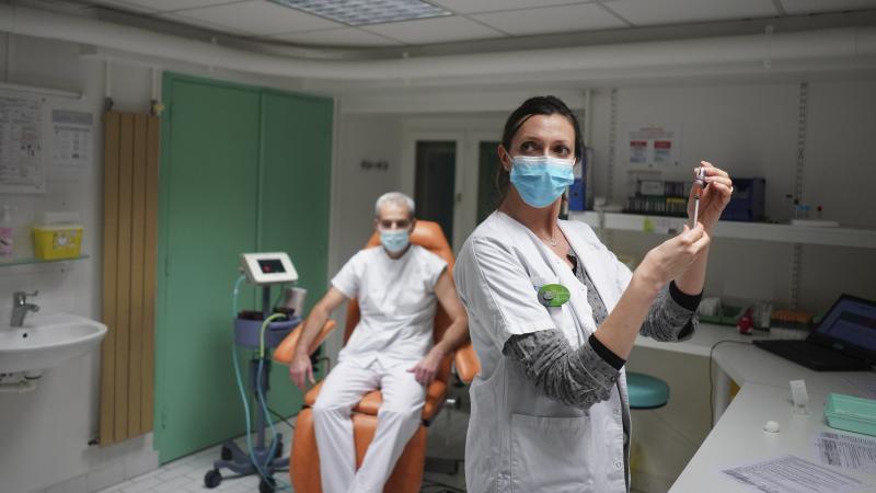 A nurse prepares to administer the Pfizer-BioNTech COVID-19 vaccine to Dr. Jean-Christophe Richard in La Croix-Rousse hospital, in Lyon, France, on Wednesday. Amid public outcry, France's health minister promised Tuesday an "exponential" acceleration of h A nurse prepares to administer the Pfizer-BioNTech COVID-19 vaccine to Dr. Jean-Christophe Richard in La Croix-Rousse hospital, in Lyon, France, on Wednesday. Amid public outcry, France's health minister promised Tuesday an "exponential" acceleration of h