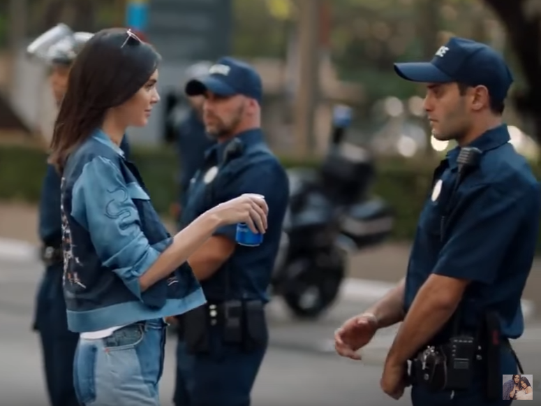 In Pepsi's new ad, model Kendall Jenner joins a protest march and hands a soda to a police officer. Following a widespread backlash, the company announced on Wednesday that it would halt a wider rollout of the video. In Pepsi's new ad, model Kendall Jenner joins a protest march and hands a soda to a police officer. Following a widespread backlash, the company announced on Wednesday that it would halt a wider rollout of the video.