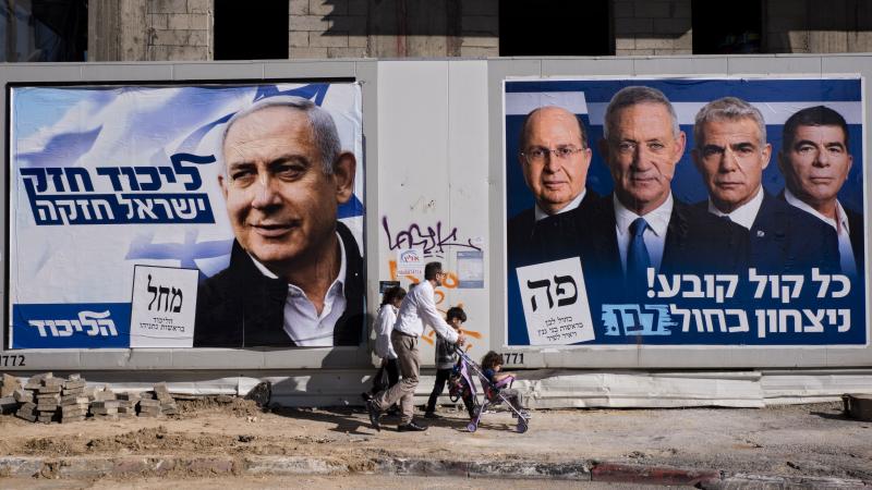 People walk by election campaign billboards showing Israeli Prime Minister and head of the Likud party Benjamin Netanyahu (left) alongside the Blue and White party leaders, including Benny Gantz. Ahead of Tuesday's election, Netanyahu has pledged to annex People walk by election campaign billboards showing Israeli Prime Minister and head of the Likud party Benjamin Netanyahu (left) alongside the Blue and White party leaders, including Benny Gantz. Ahead of Tuesday's election, Netanyahu has pledged to annex