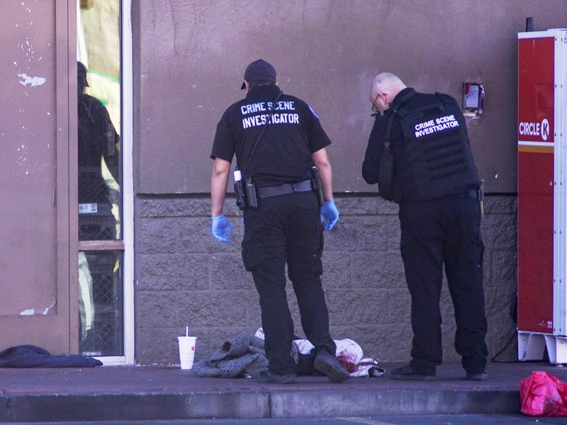 Albuquerque Police crime scene specialists photograph bloody articles of clothing after multiple people were stabbed on Sunday. Albuquerque Police crime scene specialists photograph bloody articles of clothing after multiple people were stabbed on Sunday.
