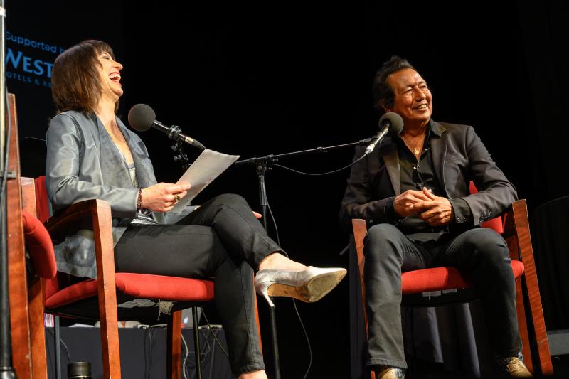 Host Ophira Eisenberg with Alejandro Escovedo on Ask Me Another at the Majestic Theatre in Dallas, Texas. Host Ophira Eisenberg with Alejandro Escovedo on Ask Me Another at the Majestic Theatre in Dallas, Texas.