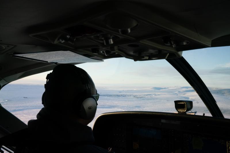 A RavnAir pilot guides a flight to Toksook Bay, Alaska, which can be seen out the window. A RavnAir pilot guides a flight to Toksook Bay, Alaska, which can be seen out the window.