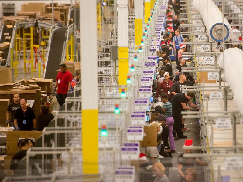 Amazon says it will pay all its U.S. workers at least $15 an hour. Here, workers prepare shipments at an Amazon Fulfillment Center in California during the early Christmas rush in 2014. Amazon says it will pay all its U.S. workers at least $15 an hour. Here, workers prepare shipments at an Amazon Fulfillment Center in California during the early Christmas rush in 2014.