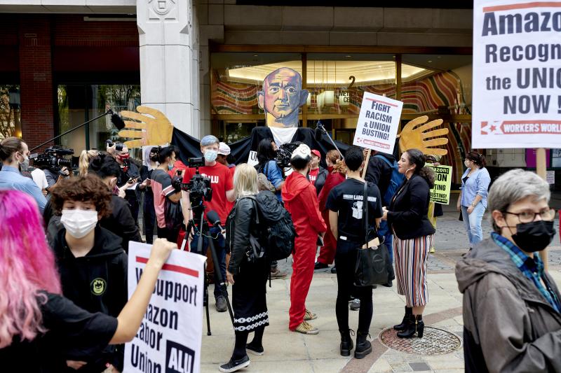 Workers and supporters hold signs after filing a petition requesting an election to form a union outside the National Labor Relations Board (NLRB) regional office in the Brooklyn Borough of New York, U.S., on Monday, Oct. 25, 2021. Amazon.com Inc. workers Workers and supporters hold signs after filing a petition requesting an election to form a union outside the National Labor Relations Board (NLRB) regional office in the Brooklyn Borough of New York, U.S., on Monday, Oct. 25, 2021. Amazon.com Inc. workers