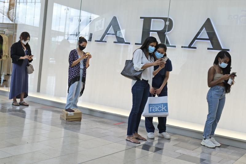 Customers wait in line to enter a Zara store inside the newly reopened Garden State Plaza mall in Paramus, N.J., on June 29. Customers wait in line to enter a Zara store inside the newly reopened Garden State Plaza mall in Paramus, N.J., on June 29.