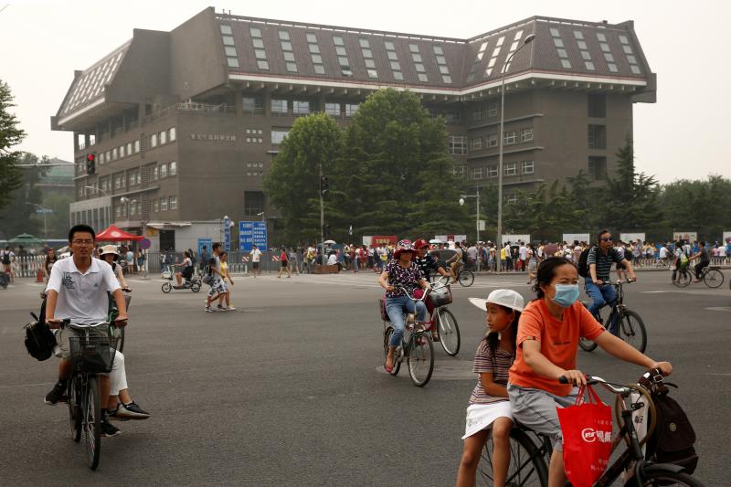 People cycle past a building at Peking University in Beijing in 2016. The university hosts Yenching Academy, a prestigious graduate studies program. People cycle past a building at Peking University in Beijing in 2016. The university hosts Yenching Academy, a prestigious graduate studies program.
