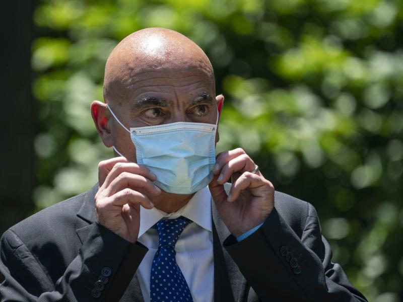 Moncef Slaoui, chief scientific adviser for Operation Warp Speed, listens as President Trump delivers remarks about coronavirus vaccine development in the Rose Garden on May 15. Slaoui says Americans could start seeing a vaccine by the middle of December. Moncef Slaoui, chief scientific adviser for Operation Warp Speed, listens as President Trump delivers remarks about coronavirus vaccine development in the Rose Garden on May 15. Slaoui says Americans could start seeing a vaccine by the middle of December.