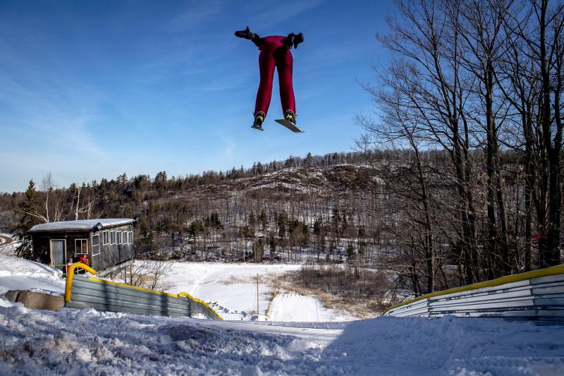 A ski jumper flies overhead on the 60-meter ski jump at the Suicide Hill Ski Bowl in Ishpeming, Mich. on March 7, 2021. The Suicide Hill Ski Bowl is home to 5 ski jumps - one being the infamous 90-meter Suicide Hill Ski Jump. A ski jumper flies overhead on the 60-meter ski jump at the Suicide Hill Ski Bowl in Ishpeming, Mich. on March 7, 2021. The Suicide Hill Ski Bowl is home to 5 ski jumps - one being the infamous 90-meter Suicide Hill Ski Jump.