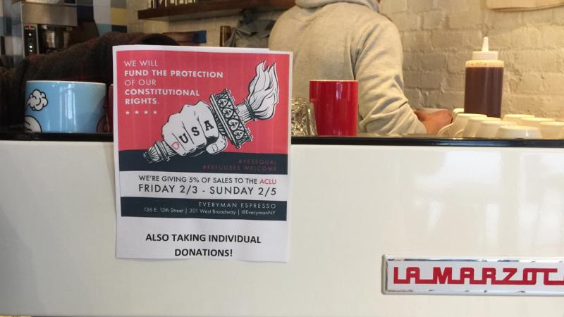 At Everyman Espresso in New York City's East Village, customers were greeted with a sign announcing a fundraiser to help defend immigrants. At Everyman Espresso in New York City's East Village, customers were greeted with a sign announcing a fundraiser to help defend immigrants.