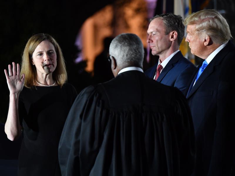President Trump watches as Supreme Court Justice Clarence Thomas administers the constitutional oath to Amy Coney Barrett during a ceremony at the White House Monday evening. President Trump watches as Supreme Court Justice Clarence Thomas administers the constitutional oath to Amy Coney Barrett during a ceremony at the White House Monday evening.