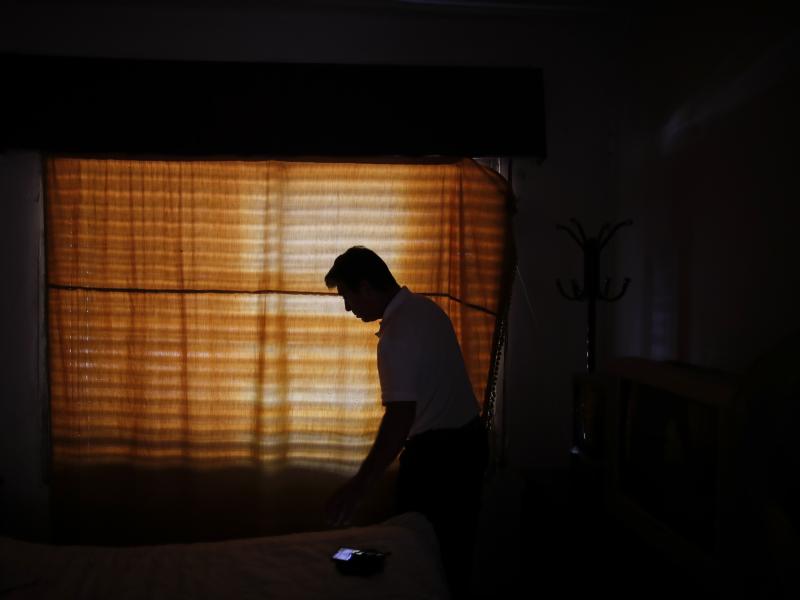 Claudio Rojas, who was deported from the U.S. in 2019, is silhouetted against a curtained window of his home in Moreno, Argentina, on May 8, 2021. He was able to return to the U.S. in August. Claudio Rojas, who was deported from the U.S. in 2019, is silhouetted against a curtained window of his home in Moreno, Argentina, on May 8, 2021. He was able to return to the U.S. in August.