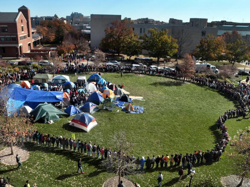 University of Missouri students circle tents on the Carnahan Quadrangle, locking arms to prevent media from entering the space following the resignation of President Timothy Wolfe on Monday. University of Missouri students circle tents on the Carnahan Quadrangle, locking arms to prevent media from entering the space following the resignation of President Timothy Wolfe on Monday.