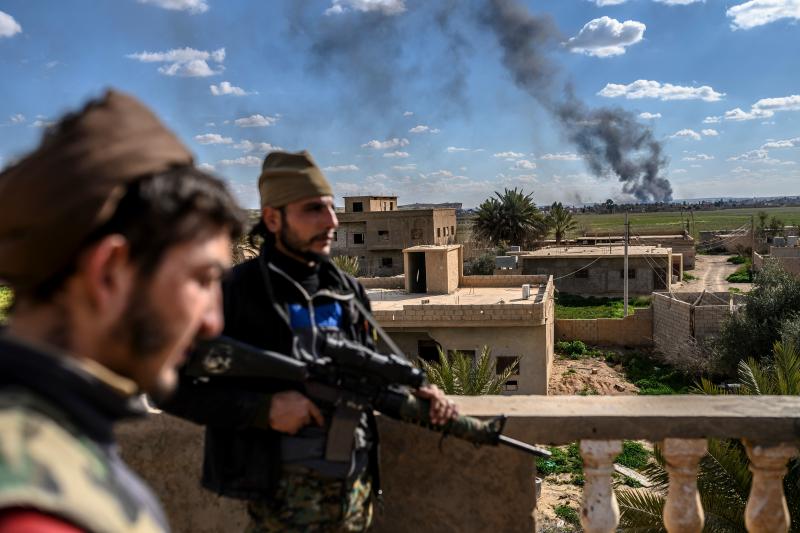 U.S.-backed fighters stand guard on a building during shelling of the Islamic State's last holdout in the town of Baghouz, Syria, on March 3. U.S.-backed fighters stand guard on a building during shelling of the Islamic State's last holdout in the town of Baghouz, Syria, on March 3.