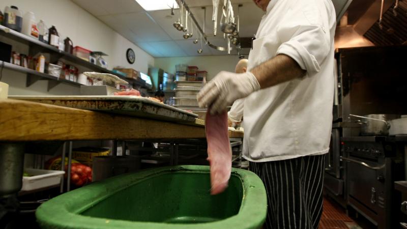 A prep cook at a San Francisco restaurant drops fish skin into a food scrap recycling container. Turning food waste into fertilizer is popular in parts of Europe and is catching on in the U.S. But tiny plastics are also making their way into that fertiliz A prep cook at a San Francisco restaurant drops fish skin into a food scrap recycling container. Turning food waste into fertilizer is popular in parts of Europe and is catching on in the U.S. But tiny plastics are also making their way into that fertiliz