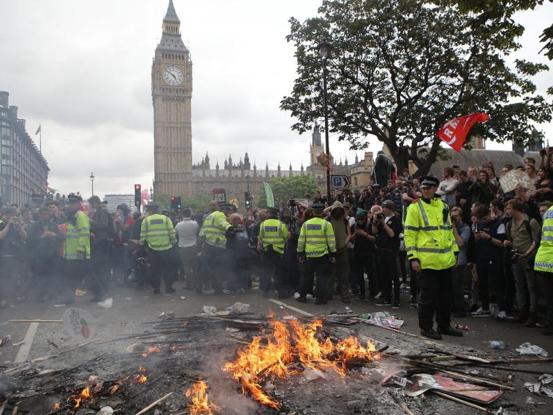 Placards are burned at the End Austerity Now rally in Parliament Square, London. Protesters have said the march was the start of a broader campaign to end government cuts to social programs. Placards are burned at the End Austerity Now rally in Parliament Square, London. Protesters have said the march was the start of a broader campaign to end government cuts to social programs.