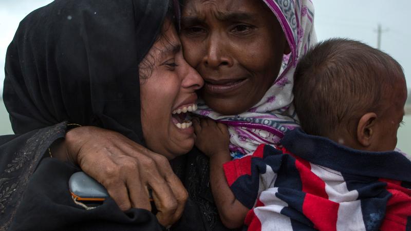 Rohingya refugees embrace one another, finally reunited after a perilous journey by boat from Myanmar to Bangladesh. Rohingya refugees embrace one another, finally reunited after a perilous journey by boat from Myanmar to Bangladesh.