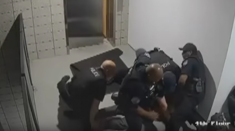 A still from surveillance footage, released by the police department in Mesa, Ariz., shows officers surrounding a man after they punched him to the ground. A still from surveillance footage, released by the police department in Mesa, Ariz., shows officers surrounding a man after they punched him to the ground.