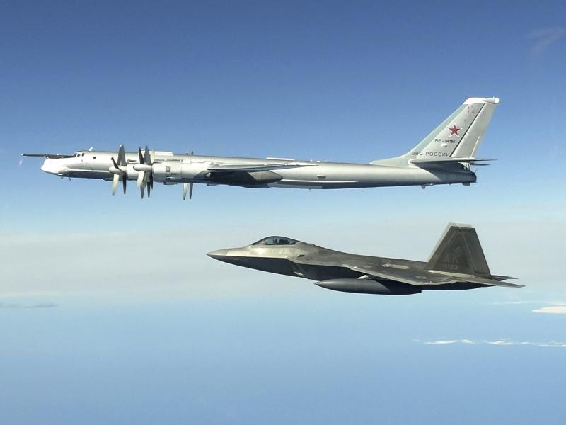 In this image taken June 16, 2020, and released by the North American Aerospace Defense Command, a Russian Tu-95 bomber (top) is intercepted by a U.S. F-22 Raptor fighter off the coast of Alaska. Russian nuclear-capable strategic bombers have flown near A In this image taken June 16, 2020, and released by the North American Aerospace Defense Command, a Russian Tu-95 bomber (top) is intercepted by a U.S. F-22 Raptor fighter off the coast of Alaska. Russian nuclear-capable strategic bombers have flown near A