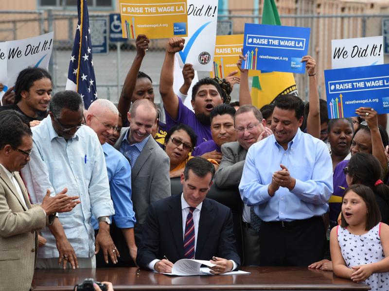 In 2015, Los Angeles Mayor Eric Garcetti (center) signs into law an ordinance raising the city's minimum wage to $15 an hour by 2020. Though California isn't one of them, 27 states have passed laws requiring cities to abide by state minimums. In 2015, Los Angeles Mayor Eric Garcetti (center) signs into law an ordinance raising the city's minimum wage to $15 an hour by 2020. Though California isn't one of them, 27 states have passed laws requiring cities to abide by state minimums.