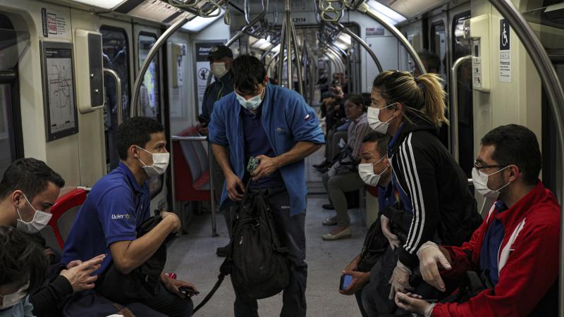 Supermarket workers wear face masks as a precaution against the spread of the new coronavirus inside the metro in Santiago, Chile, on March 18. Supermarket workers wear face masks as a precaution against the spread of the new coronavirus inside the metro in Santiago, Chile, on March 18.