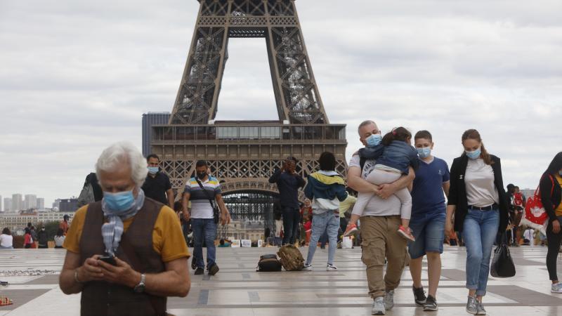 People wearing masks walk near the Eiffel Tower in Paris on Thursday, the same day that the government made masks mandatory in all the city's public outdoor spaces. People wearing masks walk near the Eiffel Tower in Paris on Thursday, the same day that the government made masks mandatory in all the city's public outdoor spaces.