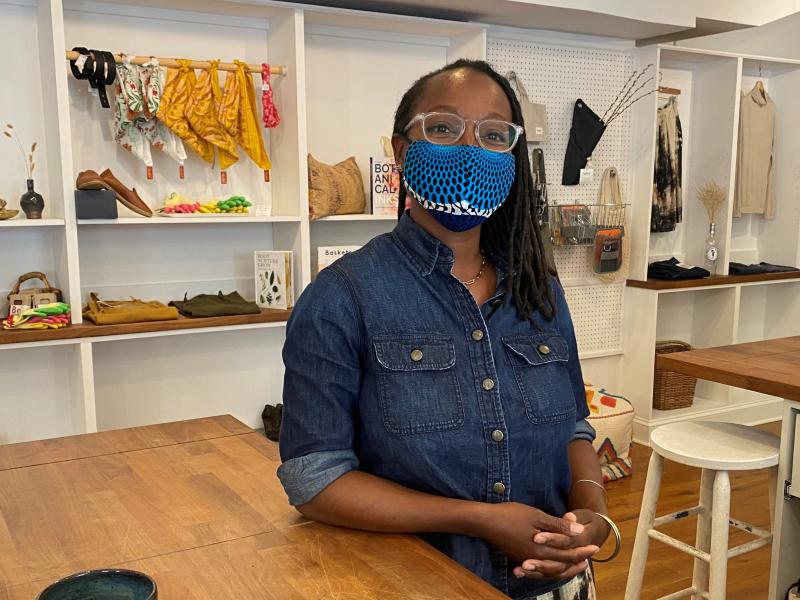 Nicole McGrew, wearing a mask by the designer N'omose Couture, says she'll require customers to mask up in her store for a short time longer. Nicole McGrew, wearing a mask by the designer N'omose Couture, says she'll require customers to mask up in her store for a short time longer.
