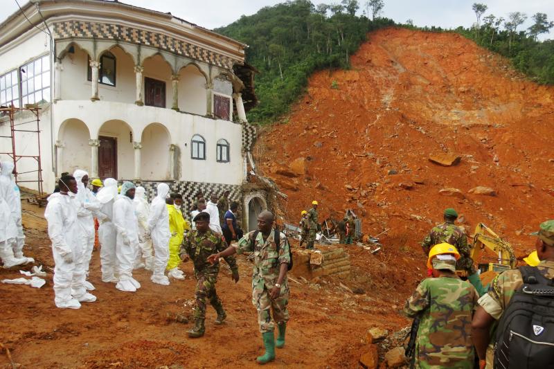 Search and rescue team members and soldiers work near a mudslide site and a damaged building near Freetown, Sierra Leone, on Tuesday. Search and rescue team members and soldiers work near a mudslide site and a damaged building near Freetown, Sierra Leone, on Tuesday.