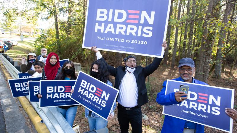 Voters wave Biden-Harris campaign signs at the entrance to a polling station in Gwinnett County, Ga., on Nov 3. Gwinnett is one of the five Atlanta metro counties that saw a dramatic increase in turnout among Asian American and Pacific Island voters this Voters wave Biden-Harris campaign signs at the entrance to a polling station in Gwinnett County, Ga., on Nov 3. Gwinnett is one of the five Atlanta metro counties that saw a dramatic increase in turnout among Asian American and Pacific Island voters this