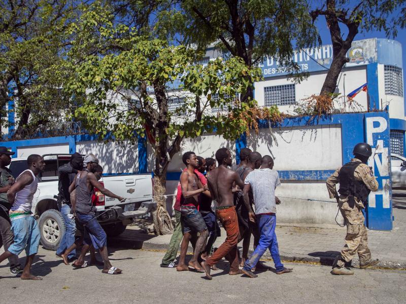 Police escort recaptured inmates back to the Croix-des-Bouquets Civil Prison after Thursday's outbreak in Port-au-Prince, Haiti. As of Friday night, authorities were still searching for more than 200 escapees. Police escort recaptured inmates back to the Croix-des-Bouquets Civil Prison after Thursday's outbreak in Port-au-Prince, Haiti. As of Friday night, authorities were still searching for more than 200 escapees.