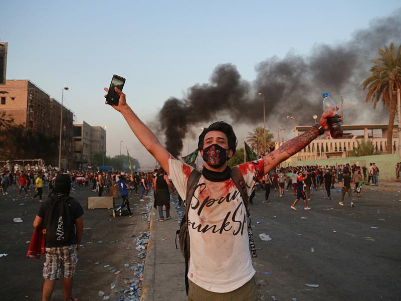 Anti-government protesters set fires and close a street during a demonstration in Baghdad on Thursday. Anti-government protesters set fires and close a street during a demonstration in Baghdad on Thursday.
