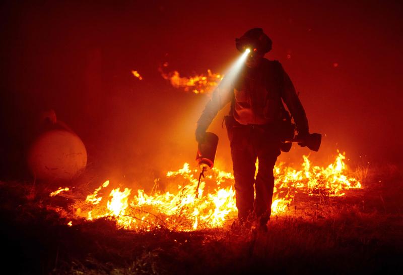 Firefighters cut defensive lines and light backfires to protect structures behind a Cal Fire fire station at the Bear Fire, part of the North Lightning Complex of fires in the Berry Creek area of Butte County, Calif., on Wednesday. Firefighters cut defensive lines and light backfires to protect structures behind a Cal Fire fire station at the Bear Fire, part of the North Lightning Complex of fires in the Berry Creek area of Butte County, Calif., on Wednesday.