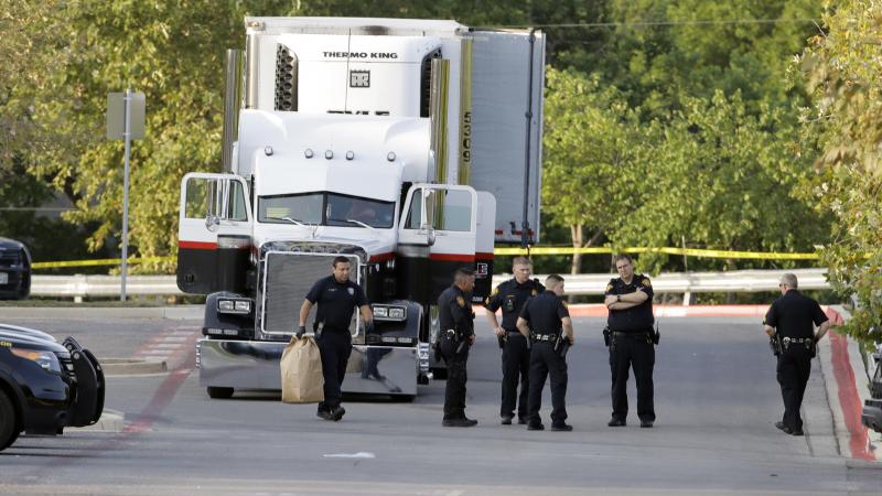 San Antonio police officers are seen in a parking lot where eight people were found dead in a tractor-trailer that contained at least 30 others outside a Walmart store. San Antonio police officers are seen in a parking lot where eight people were found dead in a tractor-trailer that contained at least 30 others outside a Walmart store.