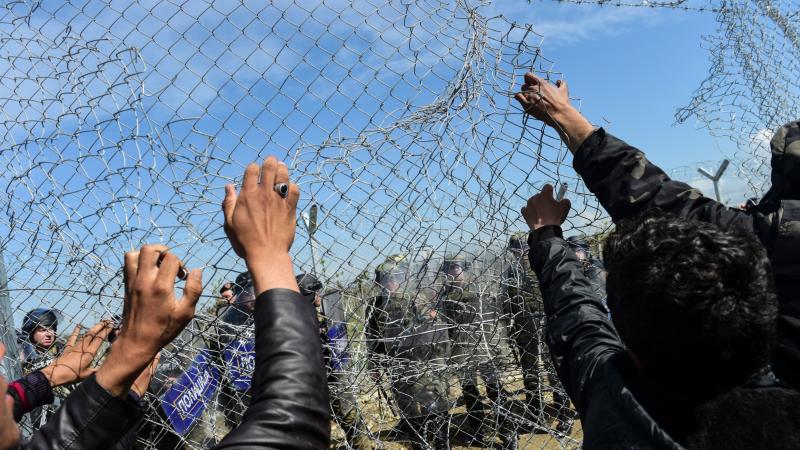 Migrants and refugees pull down a border fence during clashes with Macedonian forces Sunday near a makeshift migrant camp in the northern Greek border village of Idomeni. Migrants and refugees pull down a border fence during clashes with Macedonian forces Sunday near a makeshift migrant camp in the northern Greek border village of Idomeni.