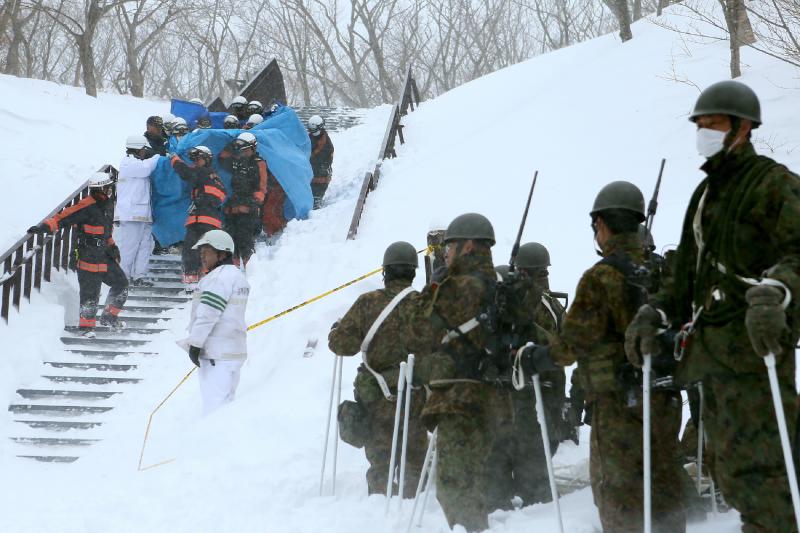 Firefighters carry a survivor they rescued from the site of an avalanche Monday in Nasu, Japan, as Self Defense Force personnel look on. Eight high school students are feared dead after an avalanche swept down on their mountain-climbing trip. Firefighters carry a survivor they rescued from the site of an avalanche Monday in Nasu, Japan, as Self Defense Force personnel look on. Eight high school students are feared dead after an avalanche swept down on their mountain-climbing trip.