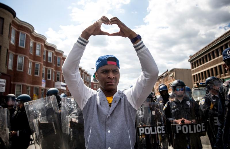 A man makes a heart shape with his hands during a peaceful protest near the CVS pharmacy that was set on fire on Monday in Baltimore. A man makes a heart shape with his hands during a peaceful protest near the CVS pharmacy that was set on fire on Monday in Baltimore.
