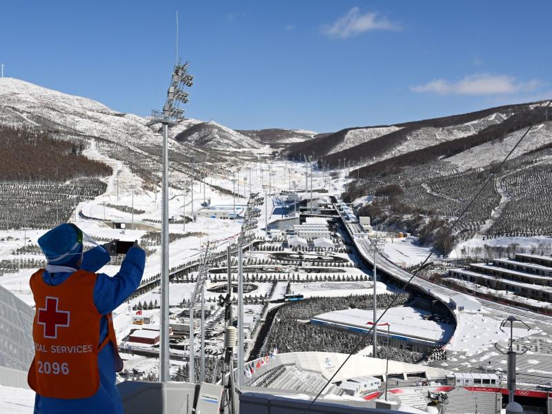 A medical helper takes a photo of the Zhangjiakou National Ski Jumping Center during the Winter Olympics on Feb. 14. A medical helper takes a photo of the Zhangjiakou National Ski Jumping Center during the Winter Olympics on Feb. 14.