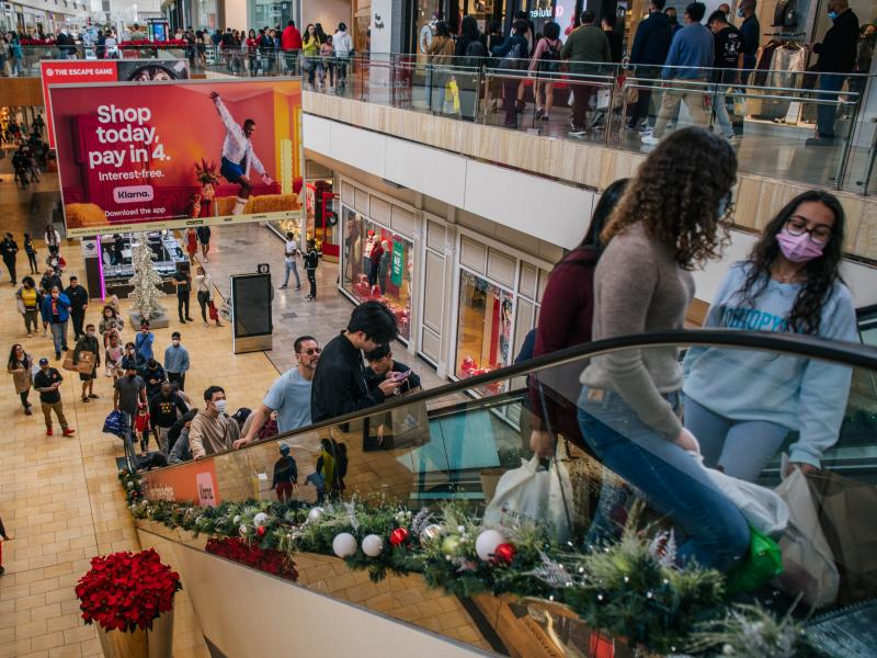 People shop in The Galleria mall in Houston during Black Friday on Nov. 26, 2021. The economy grew strongly last year but at an uneven pace because of the pandemic. People shop in The Galleria mall in Houston during Black Friday on Nov. 26, 2021. The economy grew strongly last year but at an uneven pace because of the pandemic.