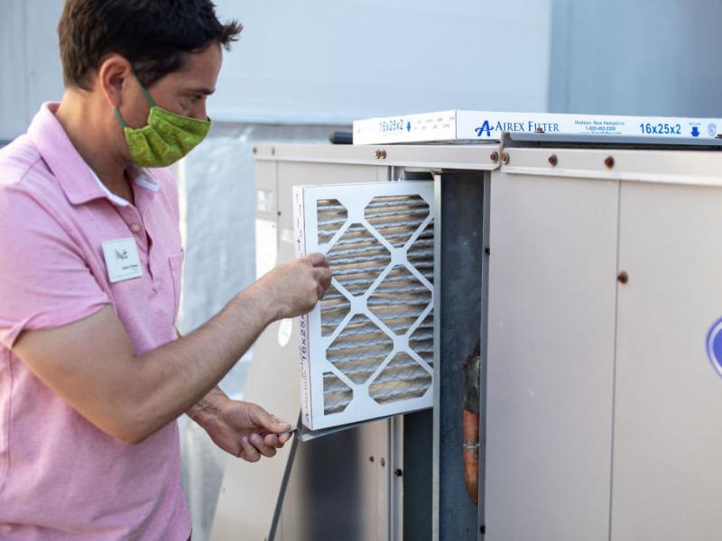 Mark Marston slides a higher-quality air filter back into an upgraded HVAC system in Portland, Maine. The new system can bring in about 30% more outside air. Mark Marston slides a higher-quality air filter back into an upgraded HVAC system in Portland, Maine. The new system can bring in about 30% more outside air.