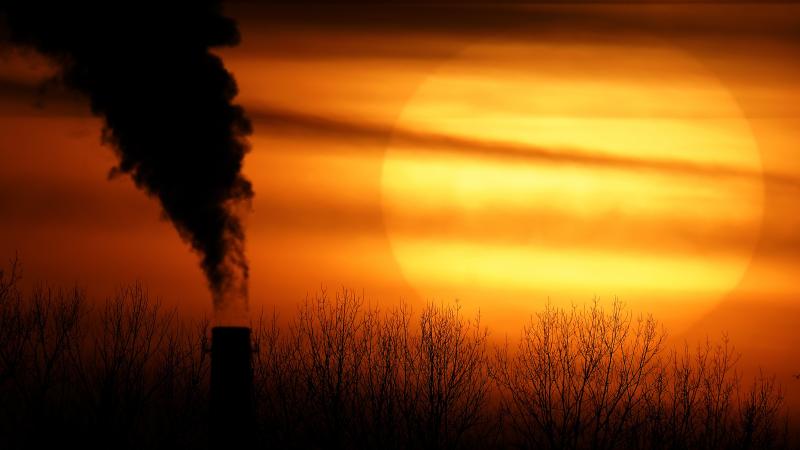 Emissions from a coal-fired power plant are silhouetted against the setting sun in Independence, Mo., in February. President Biden is announcing a new pledge for the U.S. to reduce carbon emissions under the Paris climate agreement. Emissions from a coal-fired power plant are silhouetted against the setting sun in Independence, Mo., in February. President Biden is announcing a new pledge for the U.S. to reduce carbon emissions under the Paris climate agreement.