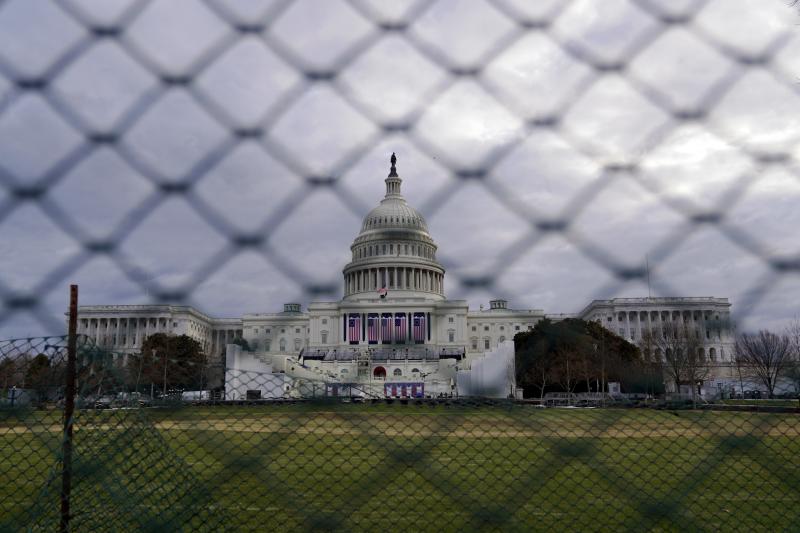 The U.S. Capitol is seen behind fences on Sunday, following the violent riot by pro-Trump extremists on Jan. 6. This week's events will have the largest security presence of any inauguration in U.S. history. The U.S. Capitol is seen behind fences on Sunday, following the violent riot by pro-Trump extremists on Jan. 6. This week's events will have the largest security presence of any inauguration in U.S. history.
