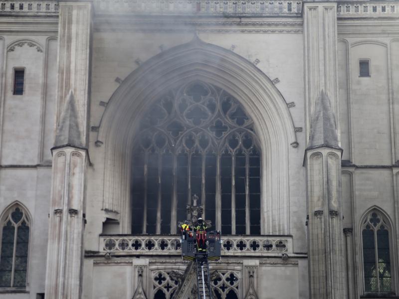 Firefighters work to extinguish the blaze at the Cathedral of St. Peter and St. Paul in Nantes on Saturday. The fire shattered stained-glass windows and sent black smoke billowing from between its two towers. Firefighters work to extinguish the blaze at the Cathedral of St. Peter and St. Paul in Nantes on Saturday. The fire shattered stained-glass windows and sent black smoke billowing from between its two towers.