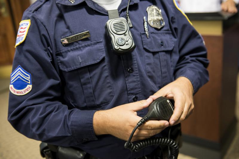 D.C. Master Patrol Officer Benjamin Fettering shows a body camera worn in place of a normal radio microphone before a news conference in 2014. D.C. Master Patrol Officer Benjamin Fettering shows a body camera worn in place of a normal radio microphone before a news conference in 2014.