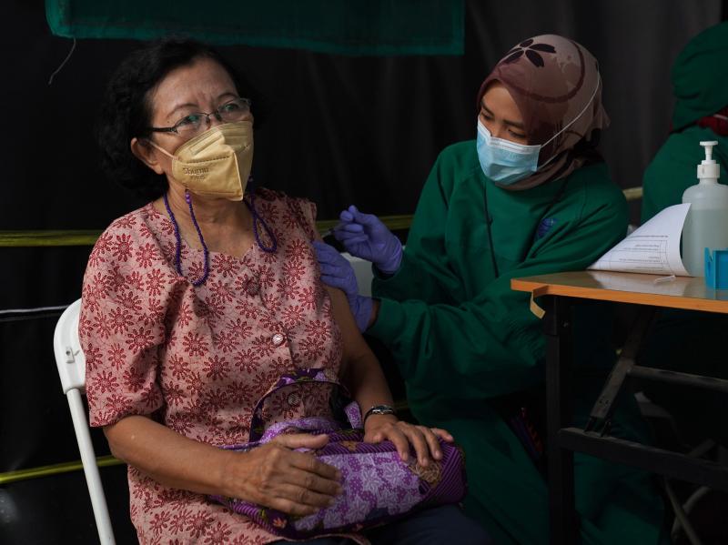 A resident receives a dose of the Pfizer COVID-19 vaccine at a health center in Jakarta, Indonesia, on Jan. 13. This week, Indonesia started a program to give booster shots to the elderly and people at risk of severe disease. A resident receives a dose of the Pfizer COVID-19 vaccine at a health center in Jakarta, Indonesia, on Jan. 13. This week, Indonesia started a program to give booster shots to the elderly and people at risk of severe disease.