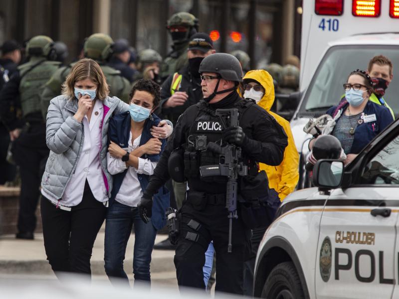 Health care workers walk out of a King Soopers grocery store after a gunman opened fire Monday in Boulder, Colo. Health care workers walk out of a King Soopers grocery store after a gunman opened fire Monday in Boulder, Colo.