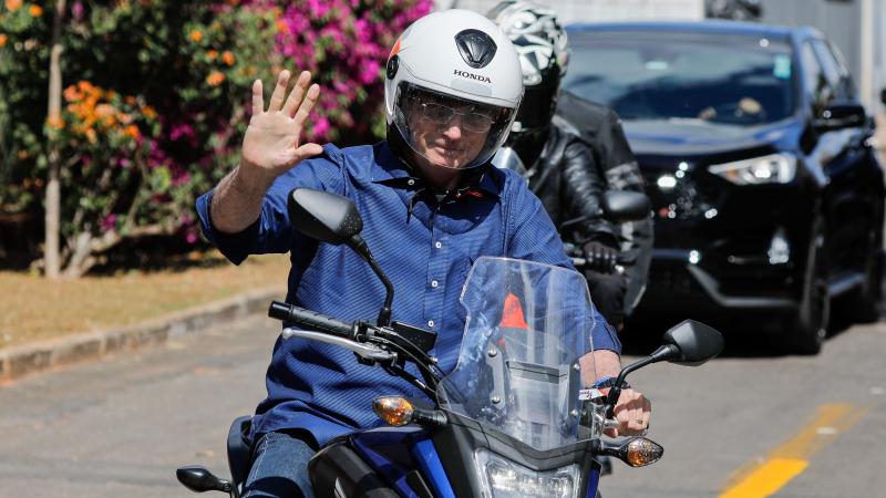 Brazilian President Jair Bolsonaro takes a ride on a motorcycle Saturday in Brasilia after he announced he tested negative for the coronavirus. He had tested positive earlier this month. Brazilian President Jair Bolsonaro takes a ride on a motorcycle Saturday in Brasilia after he announced he tested negative for the coronavirus. He had tested positive earlier this month.