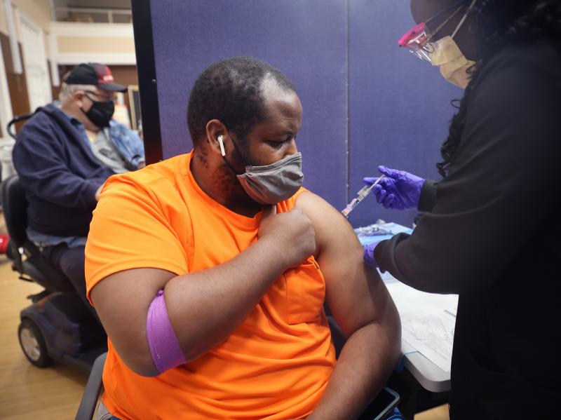 Gloria Clemons gives a COVID-19 vaccine to Navy veteran Perry Johnson at the Edward Hines, Jr. VA Hospital in Hines, Ill., in September. Gloria Clemons gives a COVID-19 vaccine to Navy veteran Perry Johnson at the Edward Hines, Jr. VA Hospital in Hines, Ill., in September.