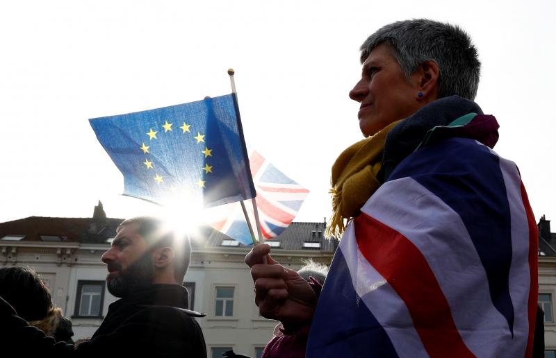 An anti-Brexit demonstrator holds British and European Union flags during a protest in front of the European Parliament in Brussels on Thursday. An anti-Brexit demonstrator holds British and European Union flags during a protest in front of the European Parliament in Brussels on Thursday.