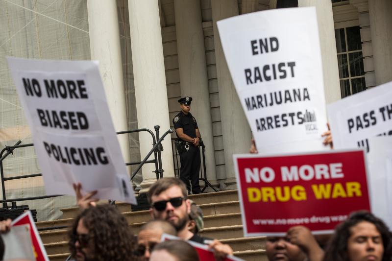 Outside New York City Hall, a policeman watches a protest against racial disparities in marijuana arrests. The majority of those arrested are black or Latino, even though those groups are not more likely to smoke pot. Outside New York City Hall, a policeman watches a protest against racial disparities in marijuana arrests. The majority of those arrested are black or Latino, even though those groups are not more likely to smoke pot.