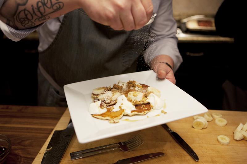 Voltaggio sprinkles sugar on granola pancakes, a dish from his new cookbook, Home. Voltaggio sprinkles sugar on granola pancakes, a dish from his new cookbook, Home.